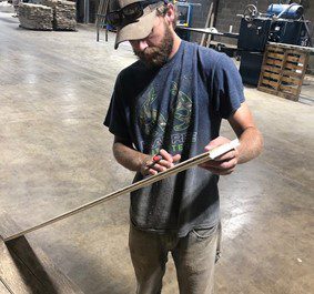 man measuring hemp board