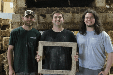 three guys holding picture frame